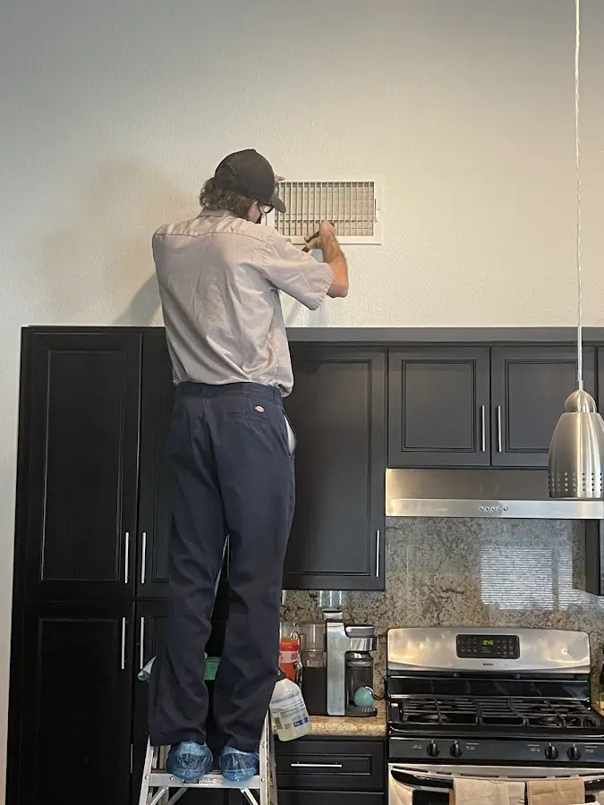 Technician inspecting an air vent during HVAC service in Cookeville